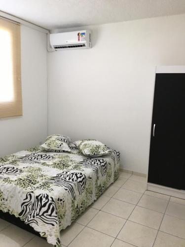 ein Schlafzimmer mit einem Bett mit einer Zebra-Decke in der Unterkunft Apartamento-Excelente localização in Resende