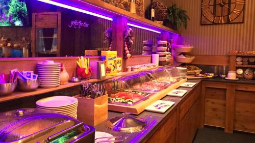 a restaurant with a buffet with purple lights at Querfurter Hof in Querfurt