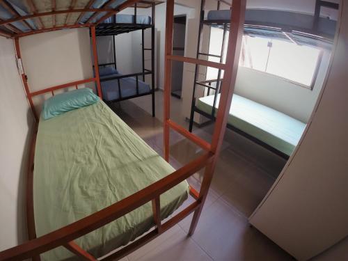 a room with three bunk beds and a window at Hostel Aventura in Alto Paraíso de Goiás