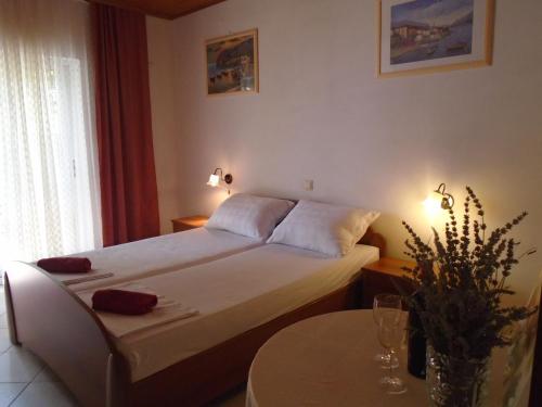 Apartments Sveti Anton في أوربيك: غرفة نوم صغيرة مع سرير وطاولة