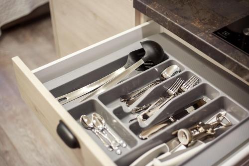 a drawer filled with silver utensils in a kitchen at Old Town Trio Apartments in Vilnius