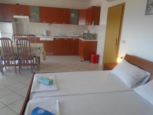 a bedroom with a bed and a kitchen with a table at Apartments Sveti Anton in Orebić