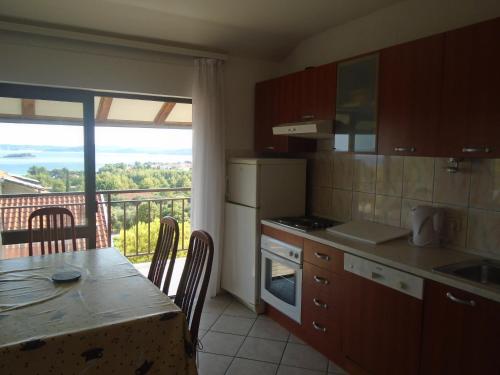 a kitchen with a table and a view of a balcony at Apartments Sveti Anton in Orebić
