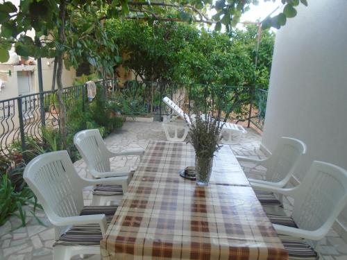 a table with white chairs and a plaid table cloth at Apartments Sveti Anton in Orebić