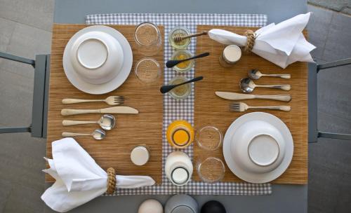 a table with plates and utensils on a cutting board at Verina Astra in Artemonas