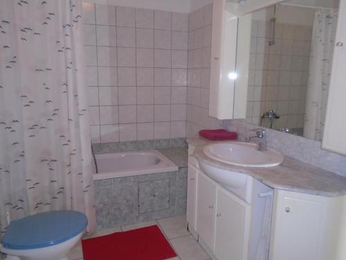a bathroom with a sink and a toilet and a tub at Apartments Sveti Anton in Orebić