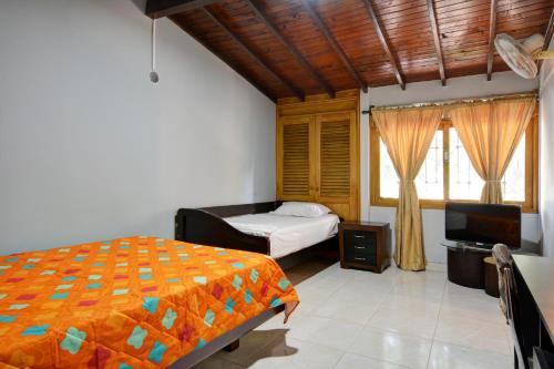 1 dormitorio con 1 cama y TV en Casa Grande Para Grupos Siete Habitaciones BiG HOUSE 7 Bedrooms, en Medellín