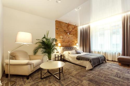 a bedroom with a bed and a couch and a chair at Old Town Trio Apartments in Vilnius