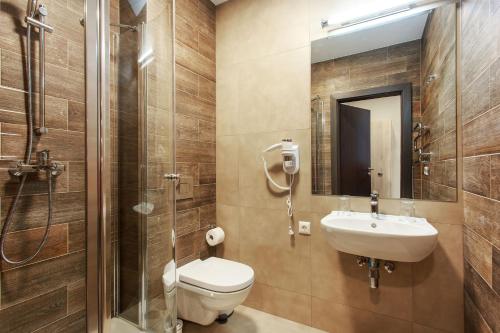 a bathroom with a toilet and a sink and a shower at Old Town Trio Apartments in Vilnius
