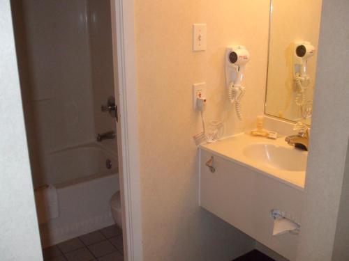 a bathroom with a sink and a mirror at Days Inn by Wyndham Trois-Rivieres in Trois-Rivières