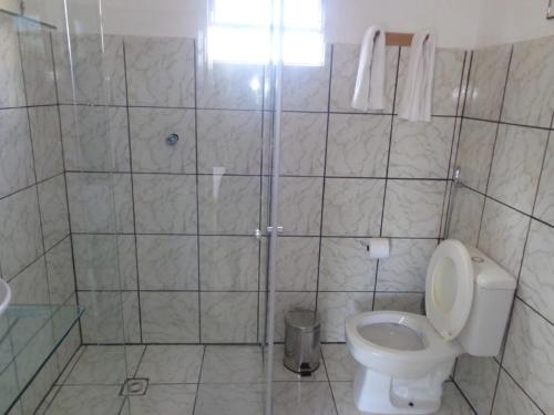 a small bathroom with a toilet and a shower at Suítes Novo Amanhecer in Sao Jorge