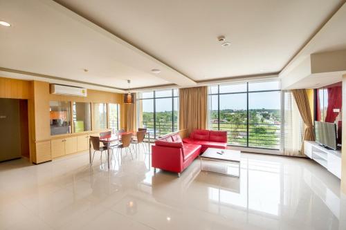 a large living room with a red couch and chairs at Paradise Resort in North Pattaya