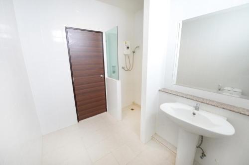 Baño blanco con lavabo y espejo en Paradise Resort, en Norte de Pattaya