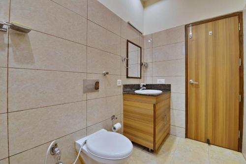 a bathroom with a toilet and a sink at Hotel Aricent in Chandīgarh