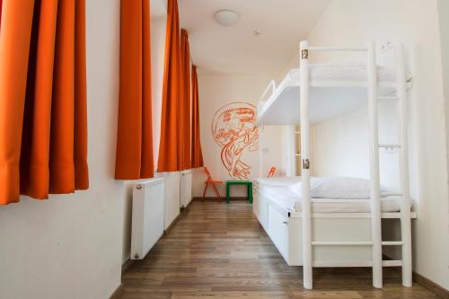 Schlafzimmer mit Etagenbett und orangefarbenen Vorhängen in der Unterkunft Safestay Prague Charles Bridge in Prag