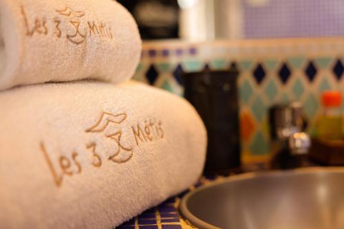 a stack of towels on a counter next to a sink at Les 3 Métis in Antananarivo