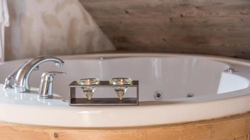 bañera con grifo y 2 velas en Vila Bijela , jacuzzi & sauna, en Jahorina