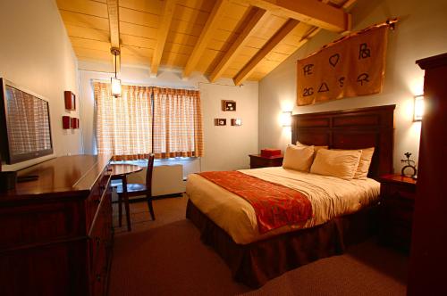 Habitación de hotel con cama, escritorio y escritorio. en Dude Rancher Lodge en Billings