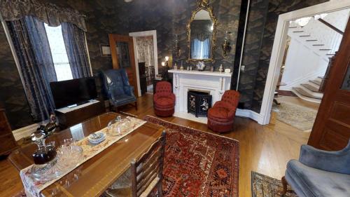 sala de estar con mesa y chimenea en Hanna House Bed & Breakfast en New Bern