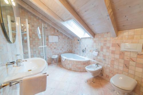 La salle de bains est pourvue d'une baignoire, d'un lavabo et de toilettes. dans l'établissement Jagerhof, à Caldaro