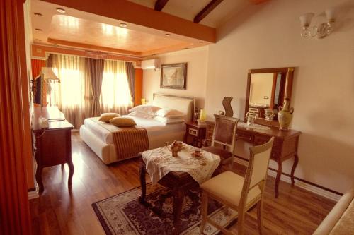 - une chambre avec un lit, une table et un bureau dans l'établissement Hotel Villa Fernando Tirana, à Tirana