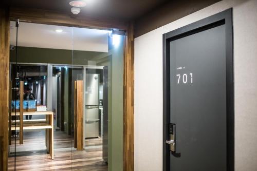 a room with a door and a room with a mirror at We Come Hostel in Taipei