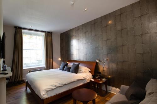 a bedroom with a bed and a couch at Hotel Du Vin & Bistro Tunbridge Wells in Royal Tunbridge Wells