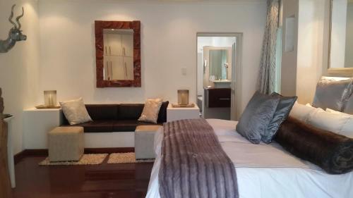 a living room with a bed and a couch at De Kloof Heritage Estate and Wellness in Swellendam