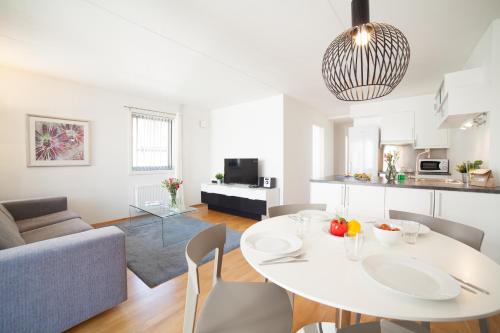 a living room with a white table and a couch at BJØRVIKA APARTMENTS, Teaterplassen, Oslo city center in Oslo
