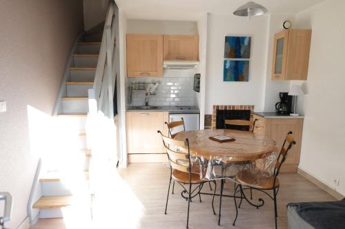 une cuisine et une salle à manger avec une table et des chaises dans l'établissement Le Cottage, à Villers-sur-Mer