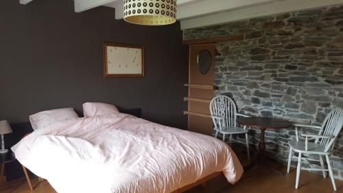 a bedroom with a bed and chairs and a brick wall at Gite Dardenne in Bertrix