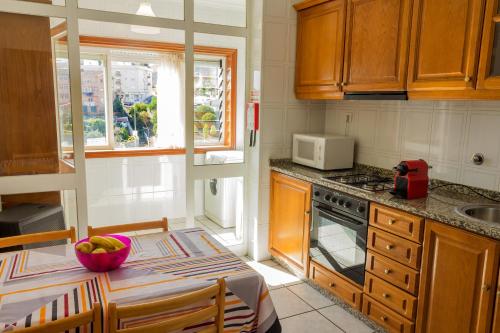 a kitchen with a table with a bowl of fruit on it at Porto RT in Rio Tinto