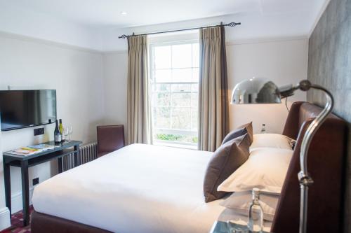a hotel room with a bed and a window at Hotel Du Vin & Bistro Tunbridge Wells in Royal Tunbridge Wells