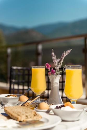 a table with plates of food and glasses of orange juice at Hotel Naiades in Órma