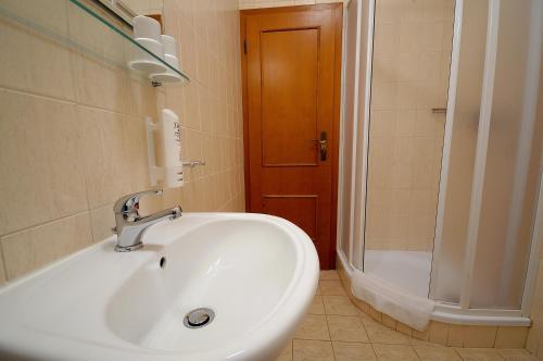 a bathroom with a white sink and a shower at Penzion Tematin in Piešťany