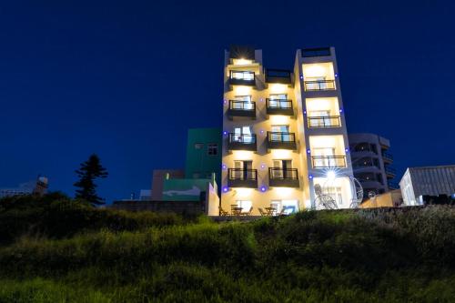 een hoog gebouw met 's nachts lichten aan bij Jia Xiang Lin Guan Hai Homestay 2 in Magong