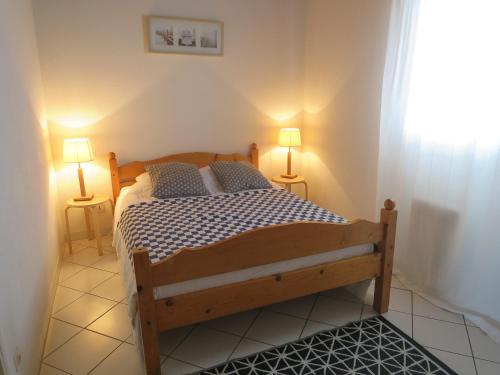 - une chambre avec un lit et deux lampes sur deux tables dans l'établissement Les Flots Bleus Etage, à Biscarrosse-Plage