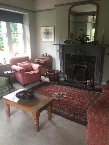 a living room with a fireplace and a table at Braeside in Alnwick