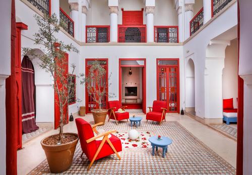 a living room filled with furniture and a red carpet at Hotel & Spa Dar Baraka & Karam in Marrakesh