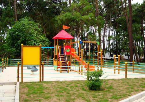 a playground with a slide in a park at Parque de Campismo Orbitur Sao Jacinto in São Jacinto