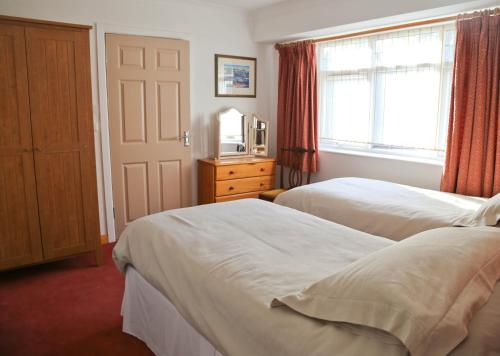 ノリッジにあるSurlingham Lodge Garden Cottageのベッド2台と窓が備わるホテルルームです。