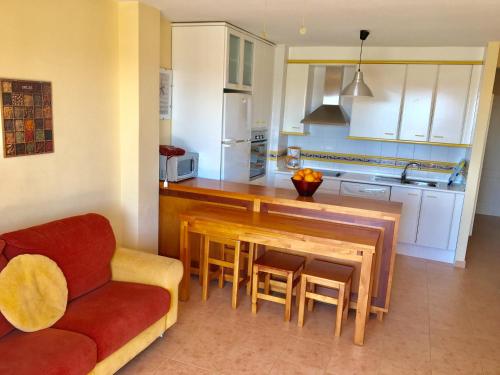 cocina con mesa de madera y silla roja en Apartamento climatizado con wifi Mar Menor, en San Pedro del Pinatar