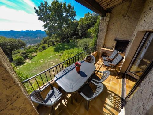 a patio with a table and chairs on a balcony at Domaine du Bois d'Amont in Cabris