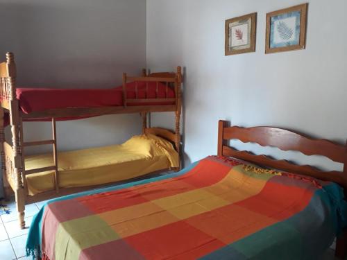 2 beliches num quarto com um cobertor colorido em Suites do Bigode em Maresias