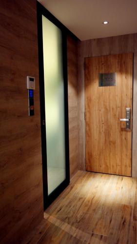 a glass door in a room with a wooden wall at Hotel Legend Boutique in Johor Bahru