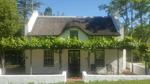 a house with vines on the front of it at De Kloof Heritage Estate and Wellness in Swellendam