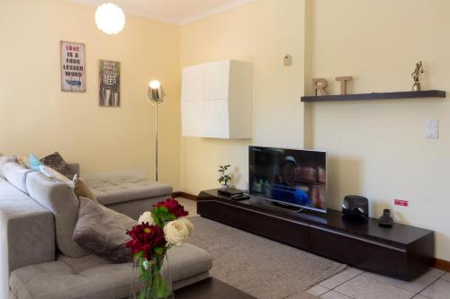 a living room with a couch and a flat screen tv at Porto RT in Rio Tinto