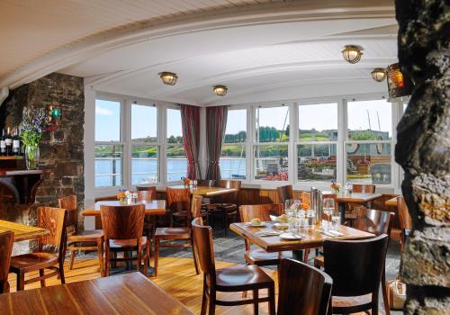 a restaurant with tables and chairs and windows at Trident Hotel Kinsale in Kinsale