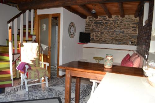 a living room with a wooden table and a chair at Casa do Conto in Doade