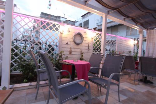 a patio with a table and chairs on a balcony at Hotel Mallas in Nea Kalikratia